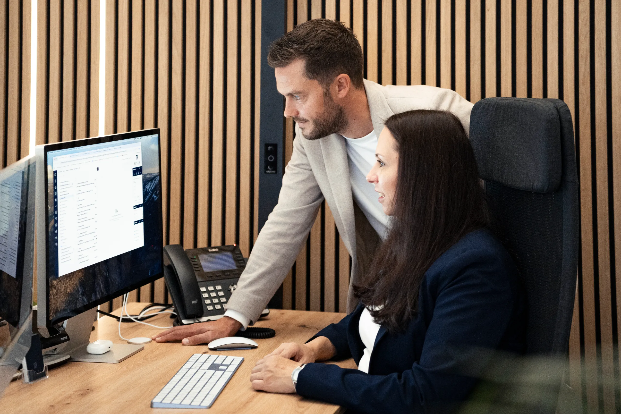 Immobilienberater und Kundin am Computer